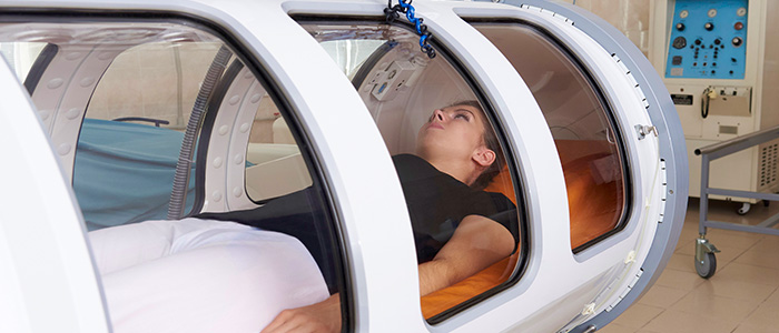 a girl laying inside a hyperbaric oxygen chamber